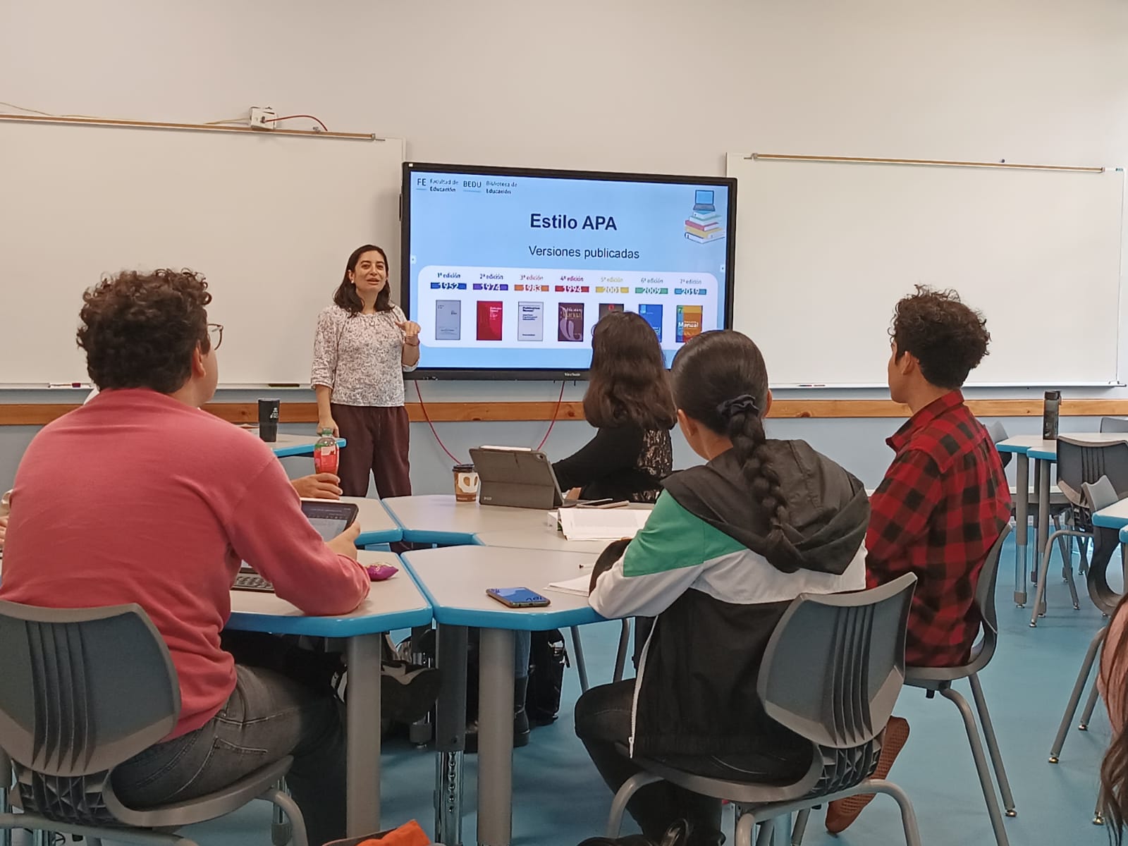 Bibliotecóloga impartiendo capacitación a estudiantes en el aula.